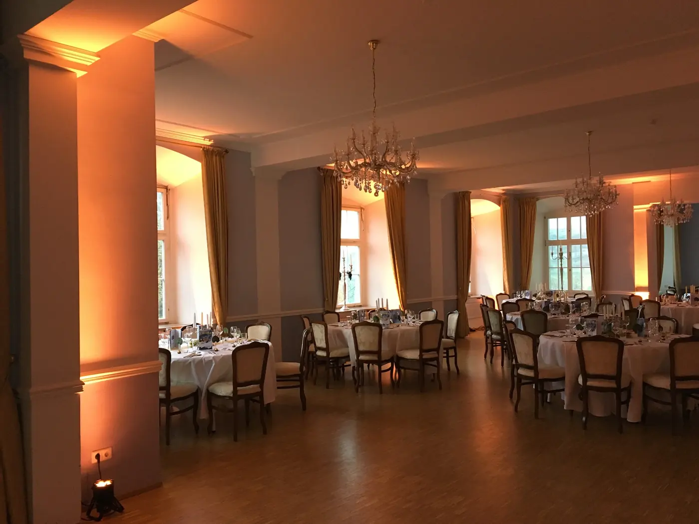 Saal mit weicher Beleuchtung und gedeckten Tischen