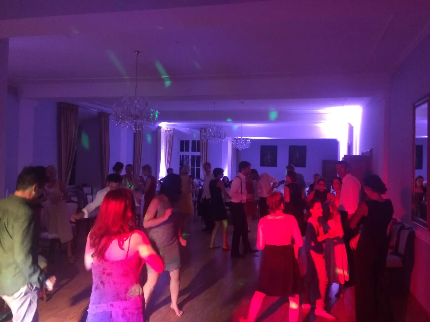 Gäste tanzen im Saal im farbigen Licht